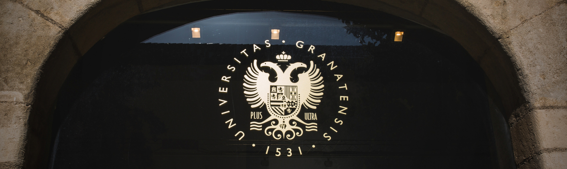 Logo de la UGR en una puerta de cristal